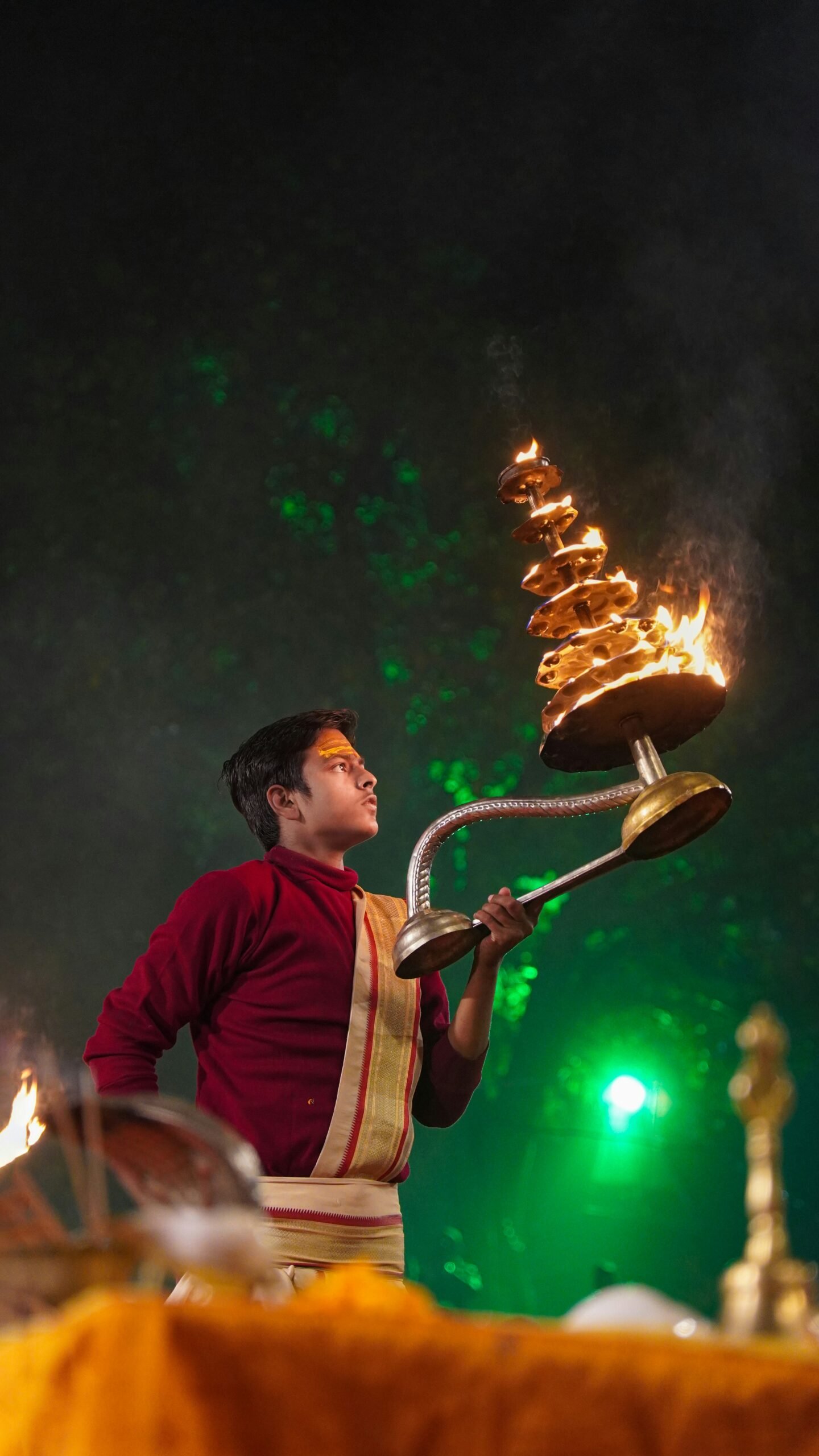 A young man holding a lit oil lamp in his hand